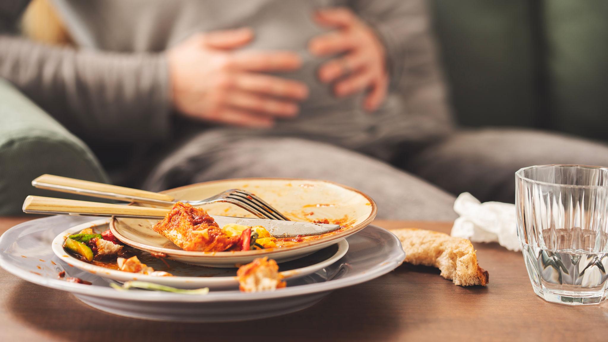 Person experiencing bloating and abdominal discomfort shortly after eating a meal