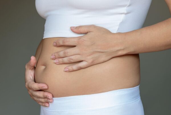 Person experiencing chronic bloating and abdominal discomfort after eating