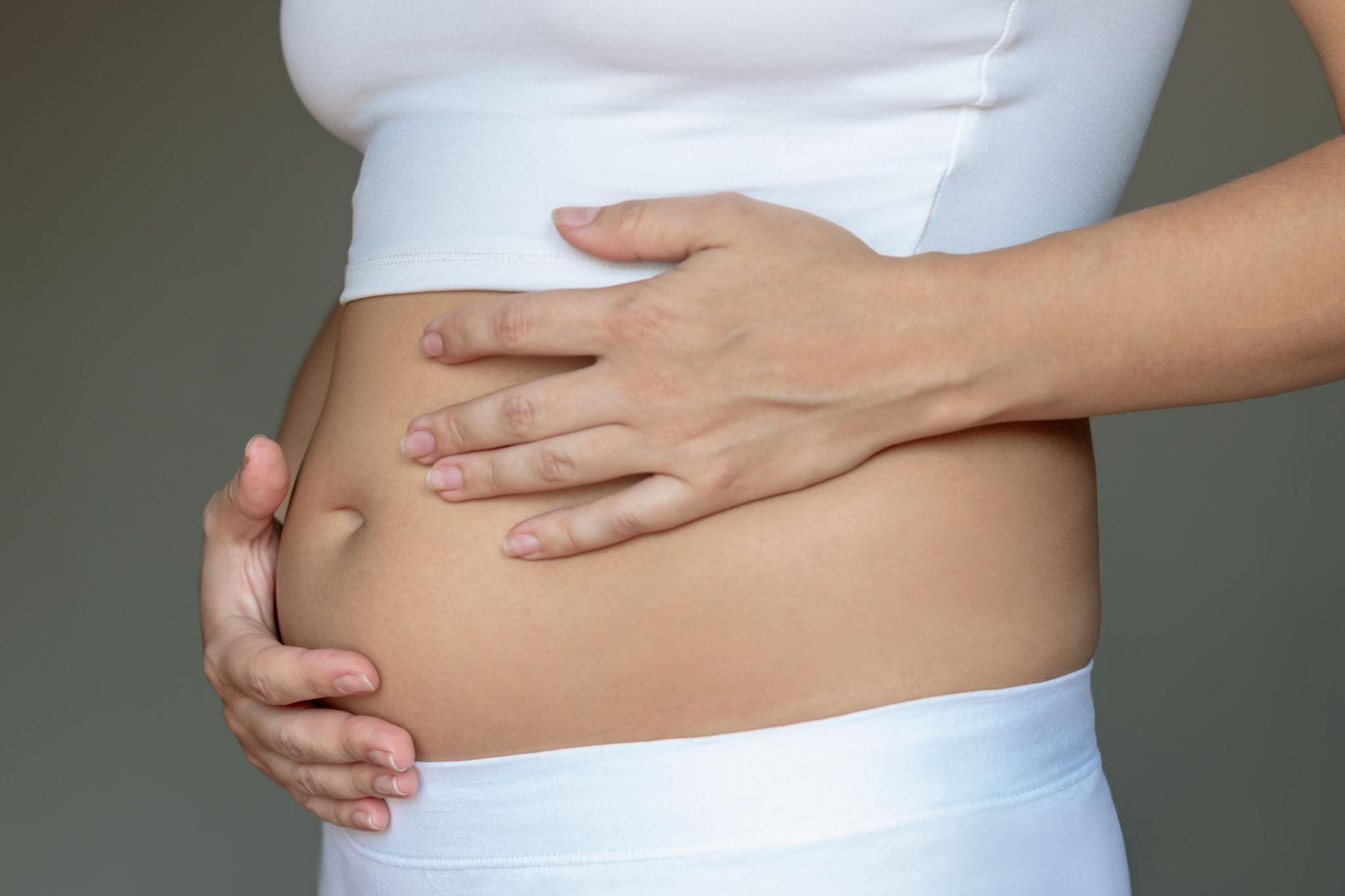 Person experiencing chronic bloating and abdominal discomfort after eating